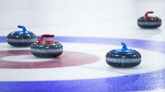 4 Curlingsteine im Zielbereich einer Curlingbahn